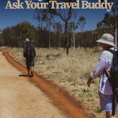 two people hiking a trail on red sand in the outback