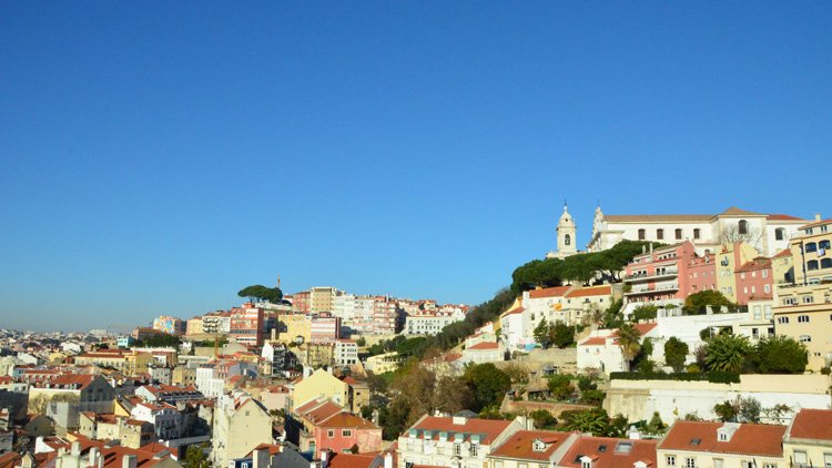 sunny day view over hills with red rooftops from buildings in Lisbon