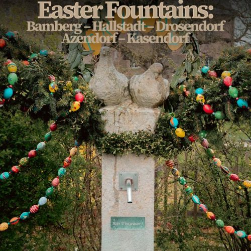 two stone doves on a stone fountain decked out in Easter branches