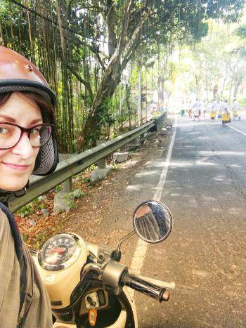 woman on scooter on tropical street