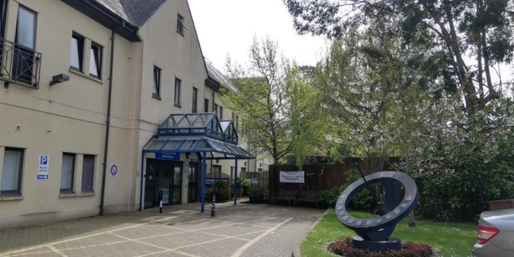 entrance of small hospital seen from parking lot
