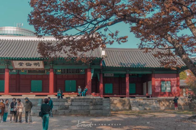 view from yard to steps and front of outdoor hall with red pillars, green detauls and black roof tiles