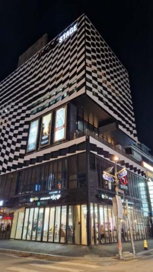 checked pattern outside of a square building at night