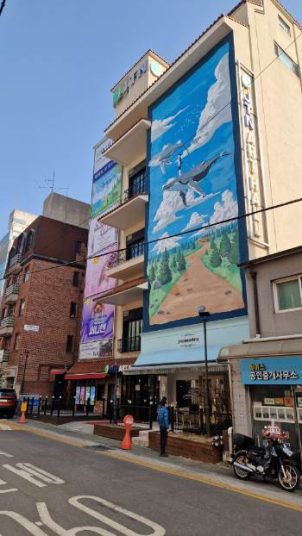 mural with flying whale painting on front facade of a modern concrete house