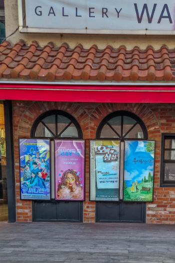 four posters in front of brick building