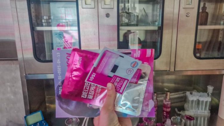 hand holding pink packs of face masks