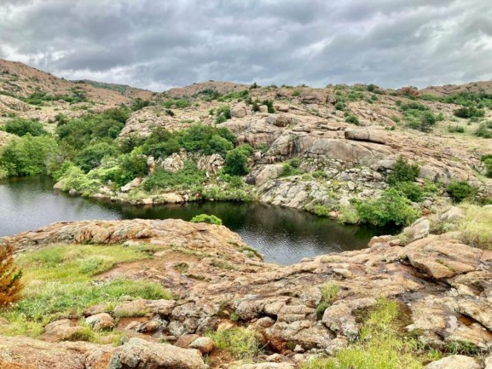 rugged rocky outcrops surrounding a body of water underneath a cloudy sky
