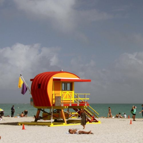 yellow and red beach house on a white sandy beach in Florida